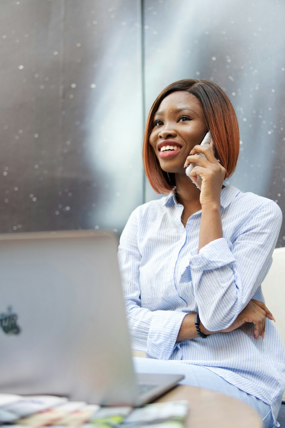 Jeune professionnelle haïtienne accueillante au téléphone dans un espace de bureau